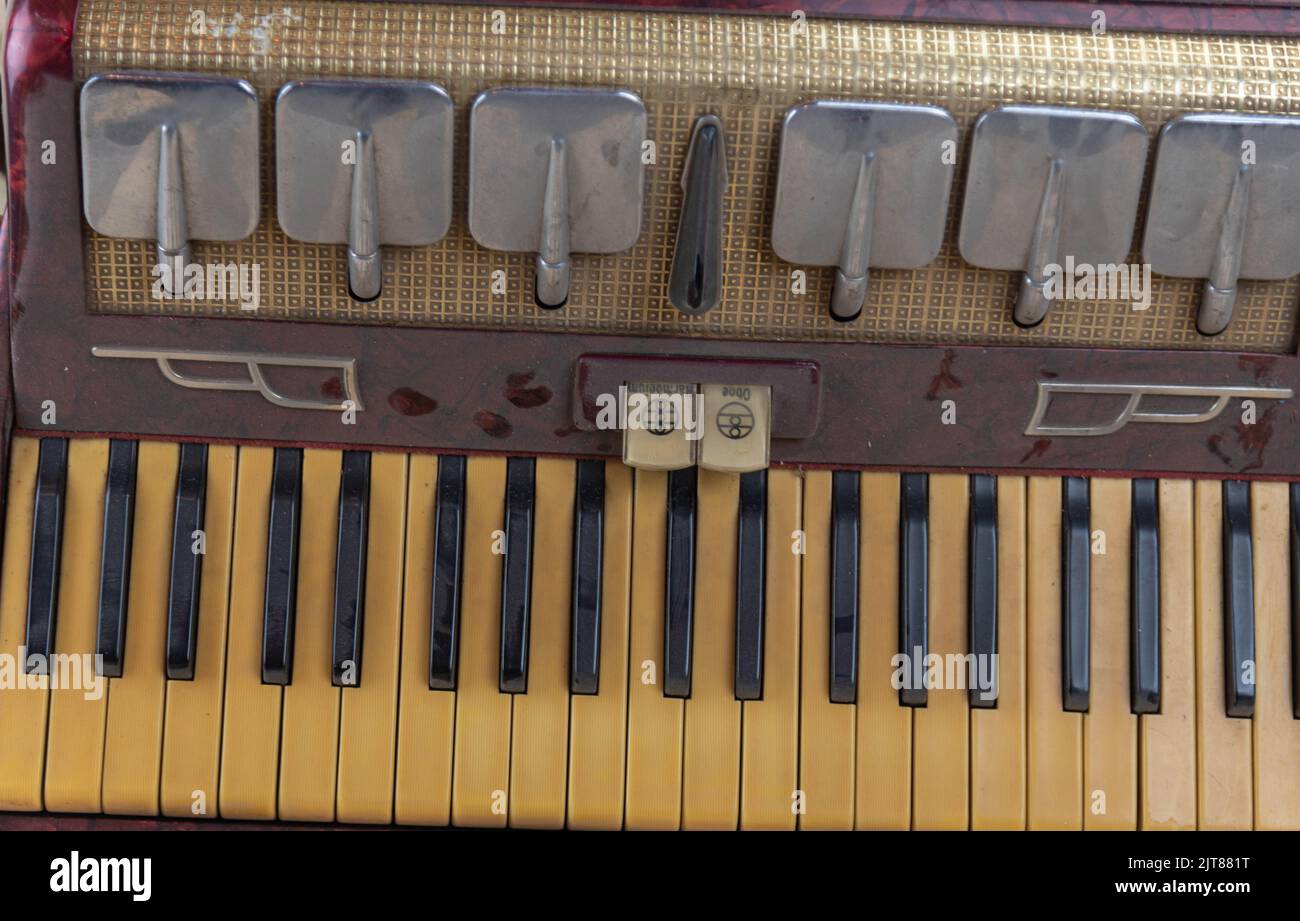 Old red accordion. Wind musical instrument. Old concertina. Musical