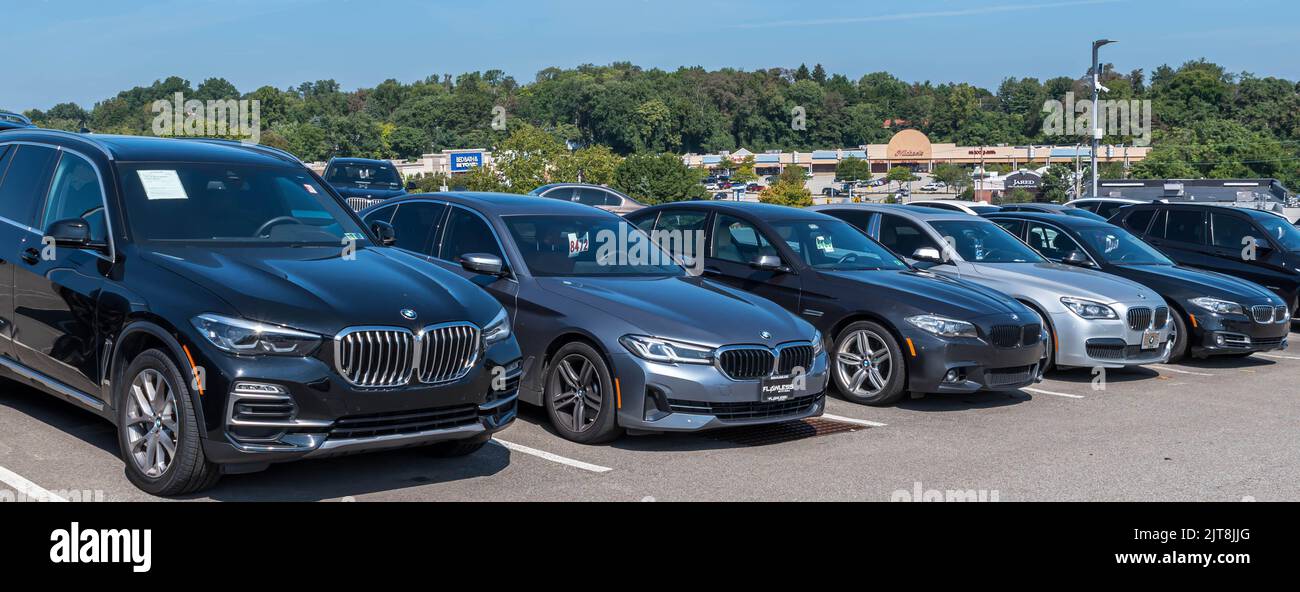 Used BMW vehicles for sale, lined up at a dealership on a sunny summer day Stock Photo