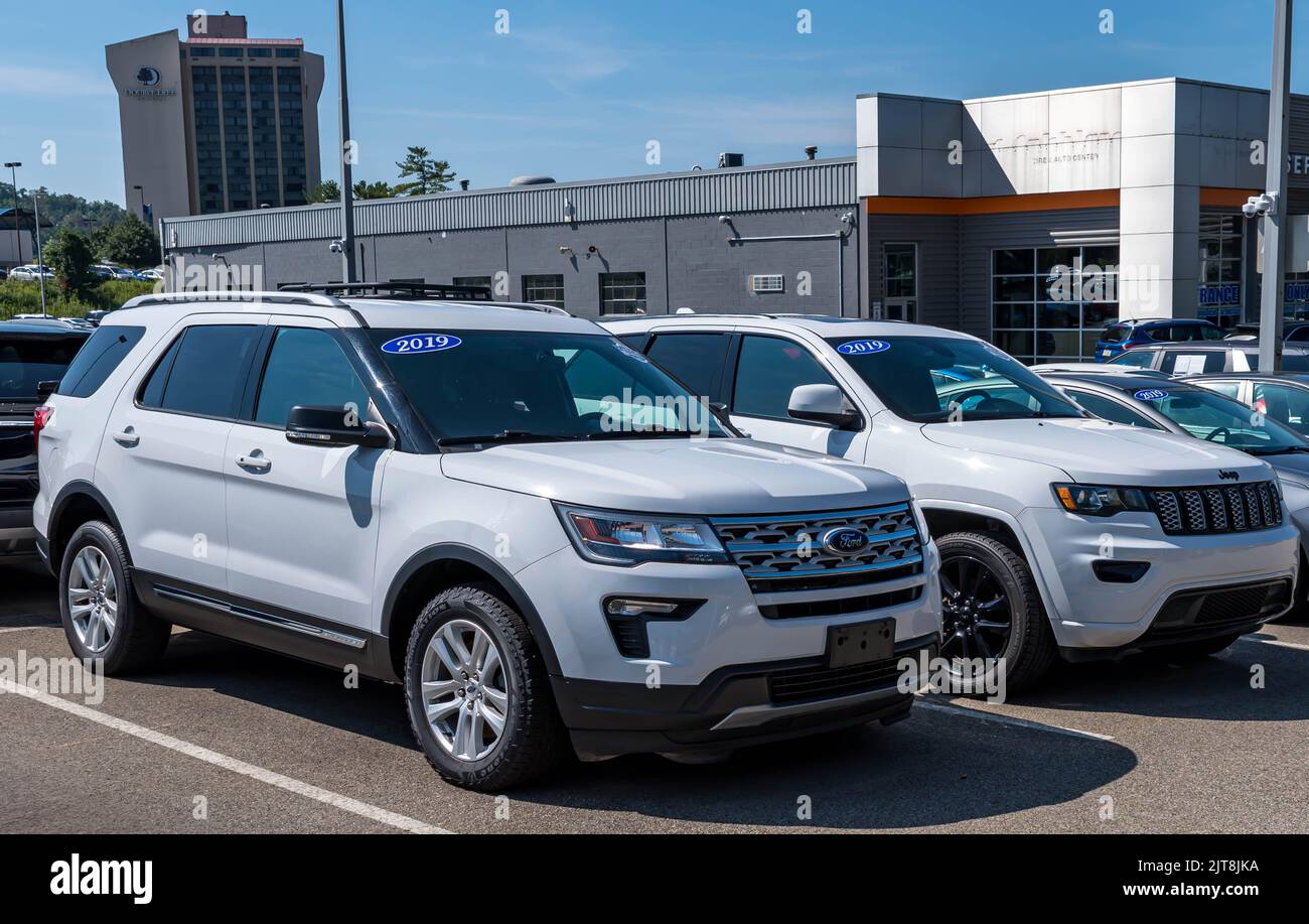 Two white SUV's, a Jeep and a Ford for sale at a dealership in