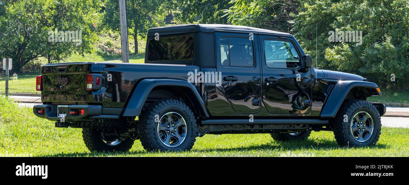 A new black Jeep Gladiator convertible SUV for sale at a dealership on a sunny summer day Stock