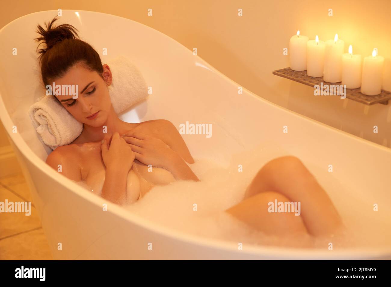 Nothing bothers her in the bathtub. High angle shot of an attractive young woman taking a bubble bath. Stock Photo