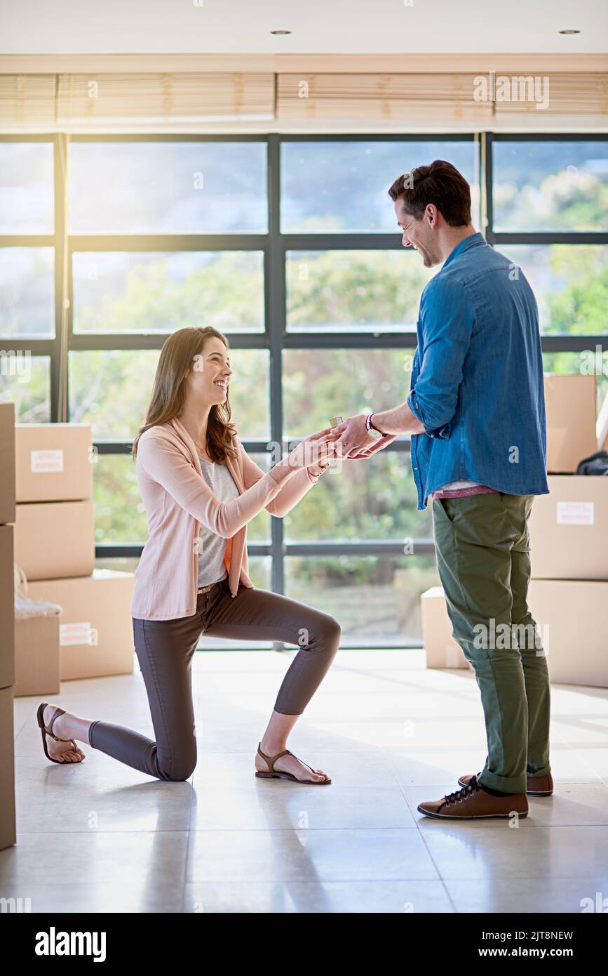 Down on bended knee. a young woman proposing to her boyfriend while moving house. Stock Photo
