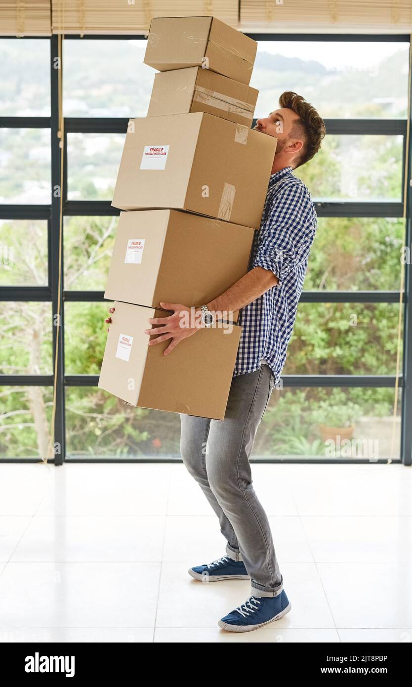 Steady now...a young man carrying a pile of boxes while moving house Stock Photo Alamy