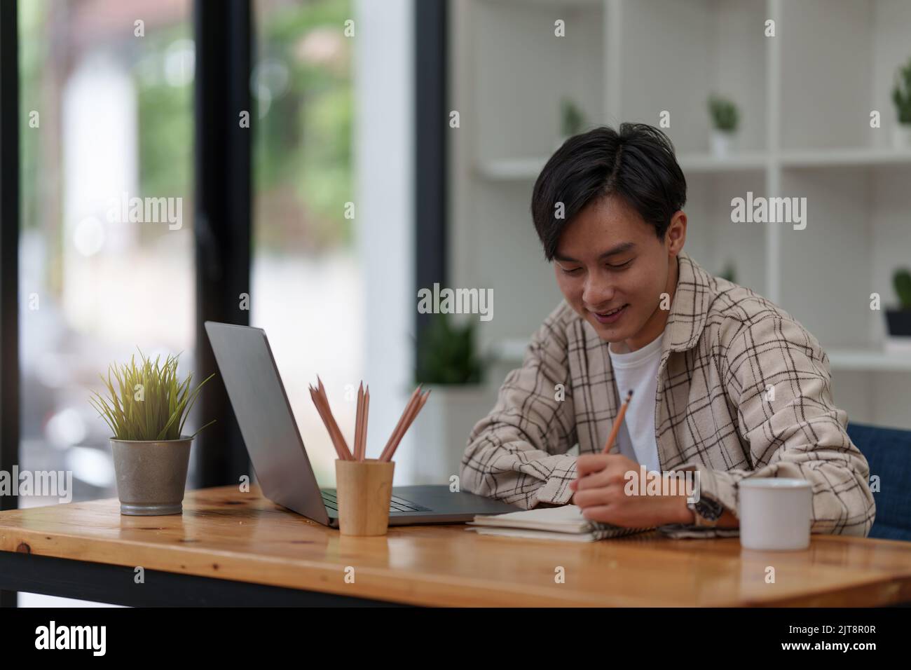 Graphic designer drawing in notebook and using laptop at home. Creative concept Stock Photo
