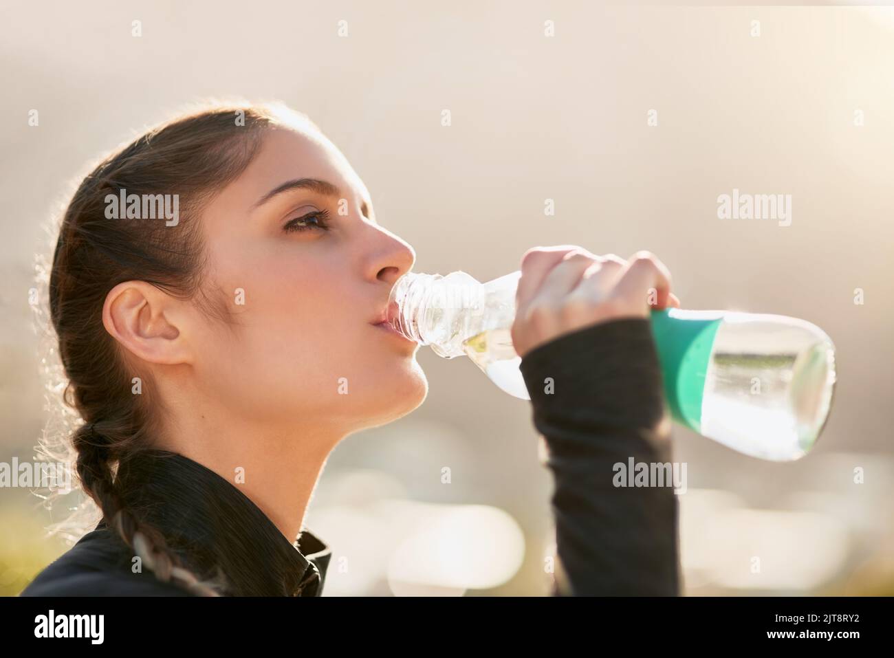 Hydrating during her workout. an attractive young woman drinking water