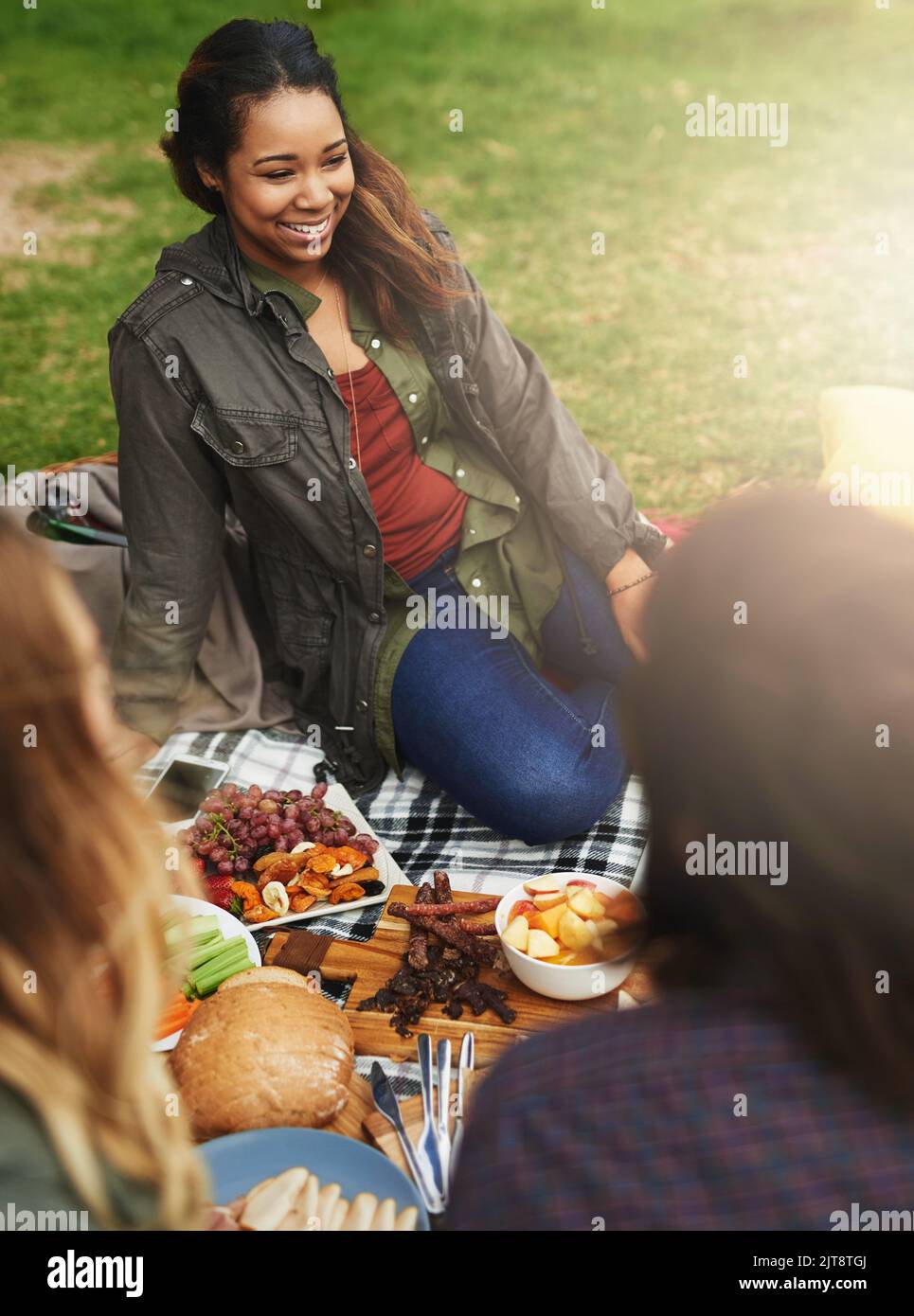 Picnic perfection. a happy young woman hanging out with her friends outside. Stock Photo