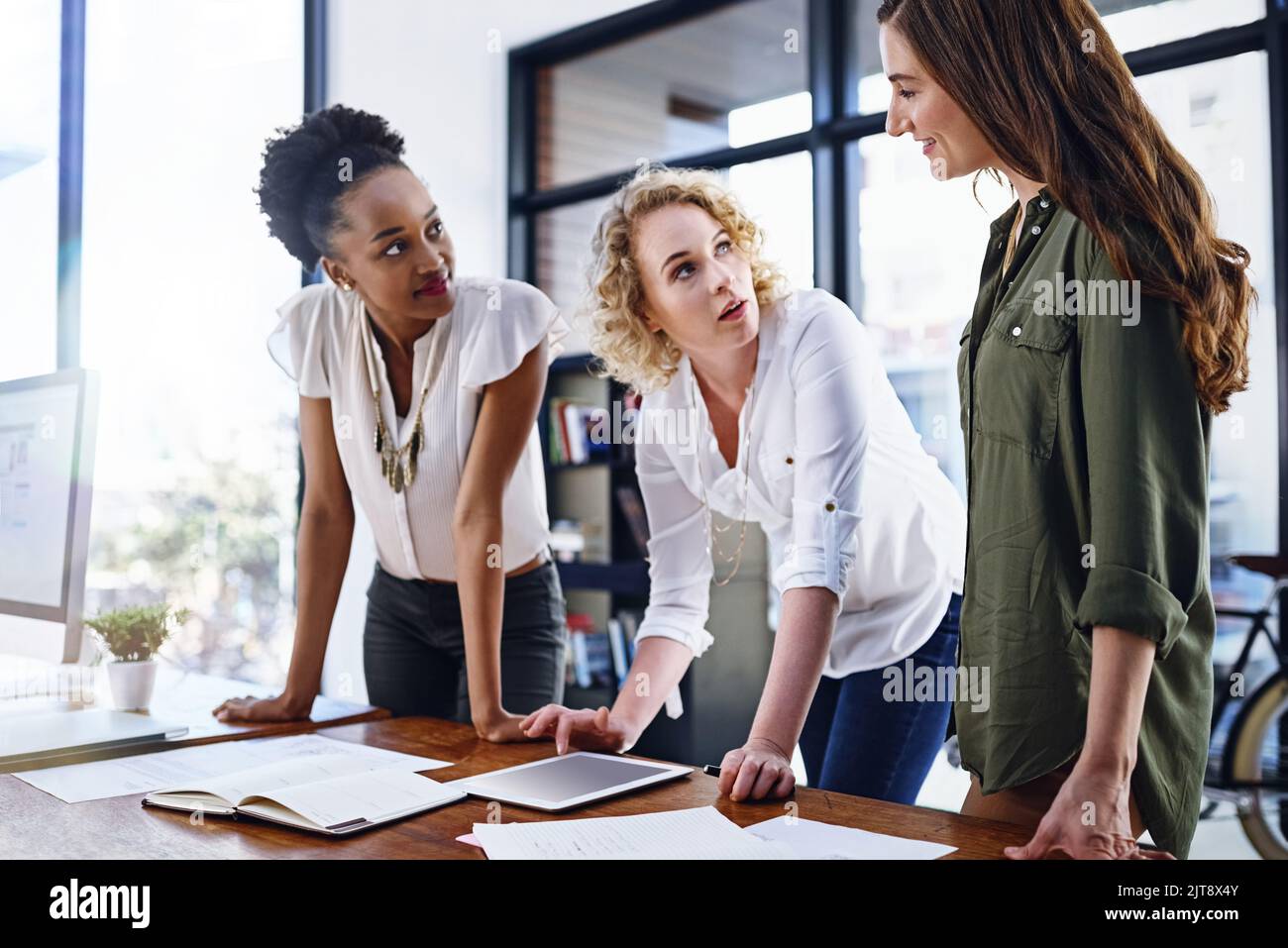 Outlining their approach together. a team of designers working together in the office. Stock Photo