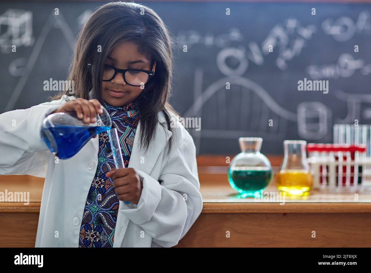 Shes got an inquisitive mind. a little girl in a lab coat doing a