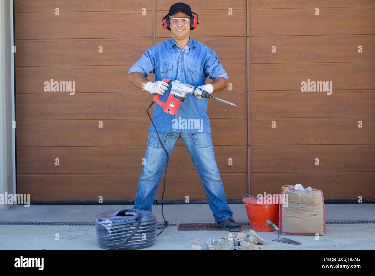 Image of a construction worker posing with demolition hammer and tools
