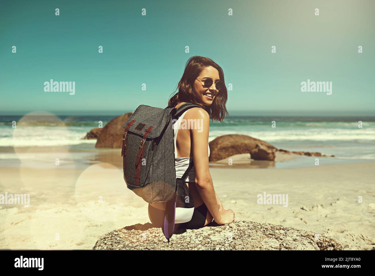 Traveling is more than the seeing of sights. a backpacker enjoying a day at the beach. Stock Photo