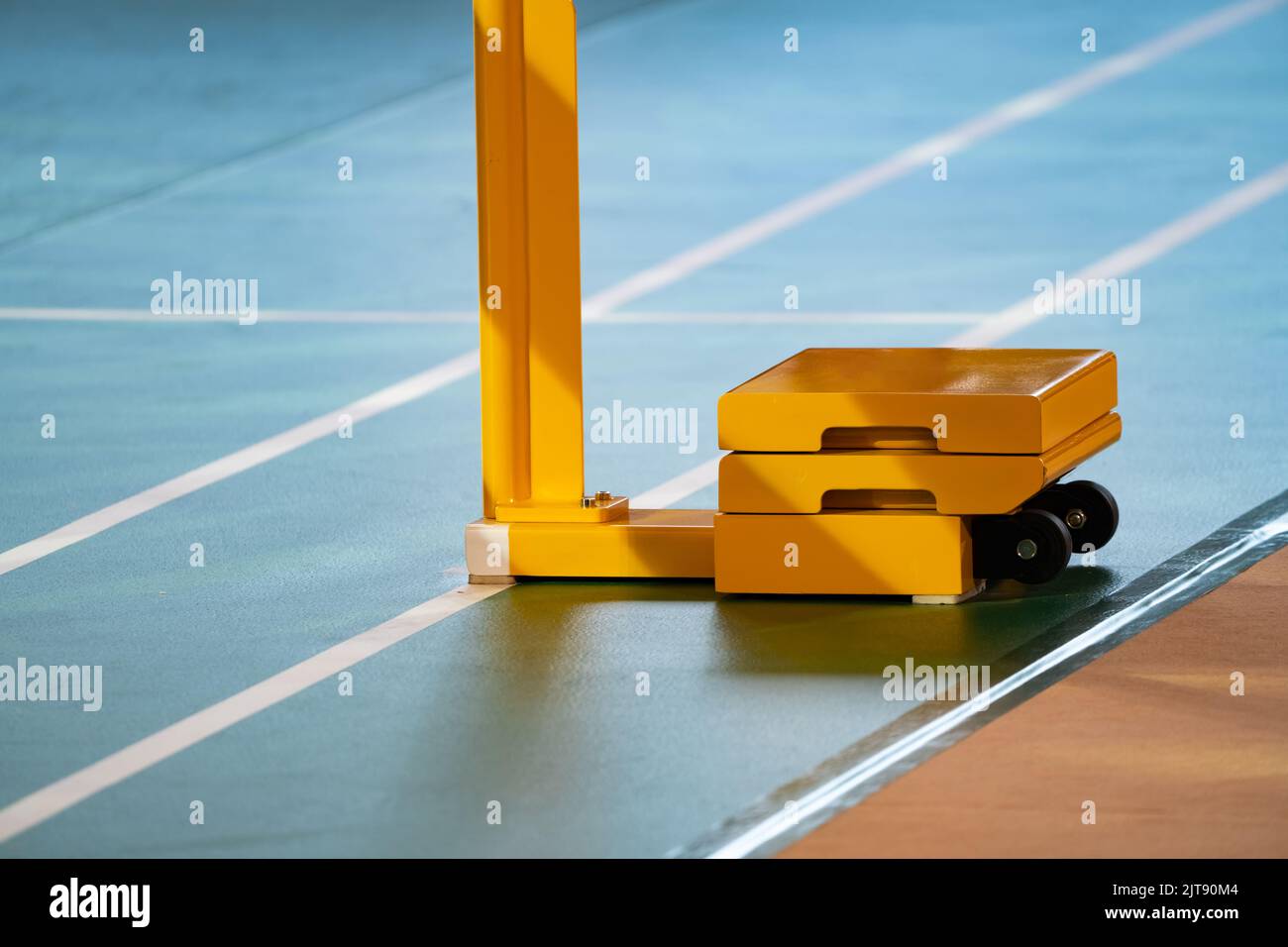 Yellow weighted pole badminton net base was placed on the side of a