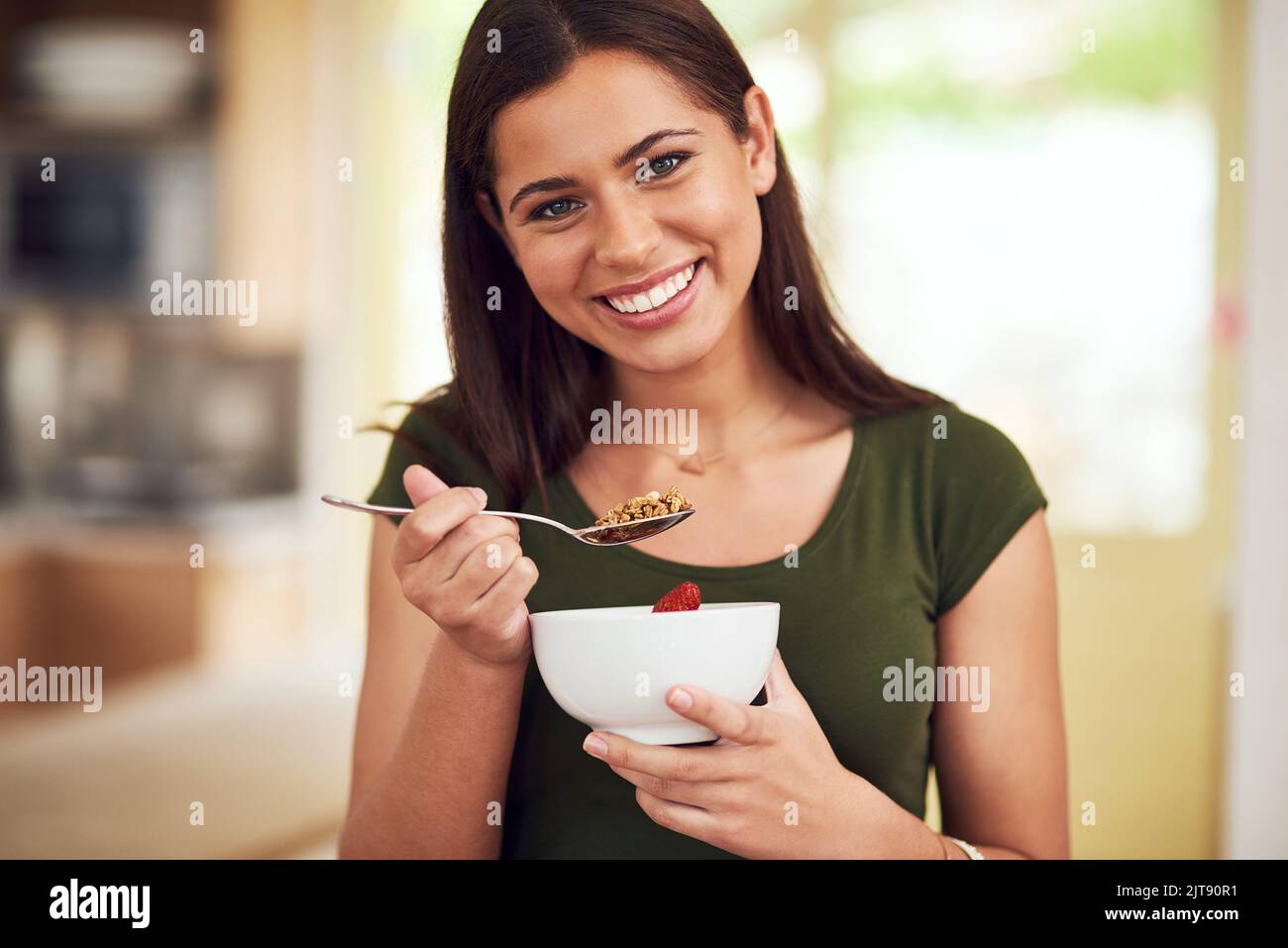 You are what you eat. Portrait of a happy young woman eating a bowl of