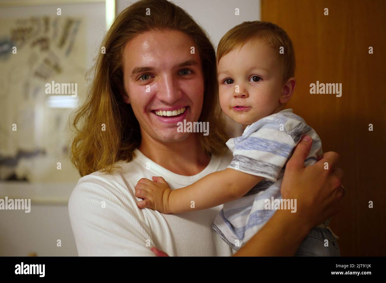 Handsome young man holding his little nephew Stock Photo