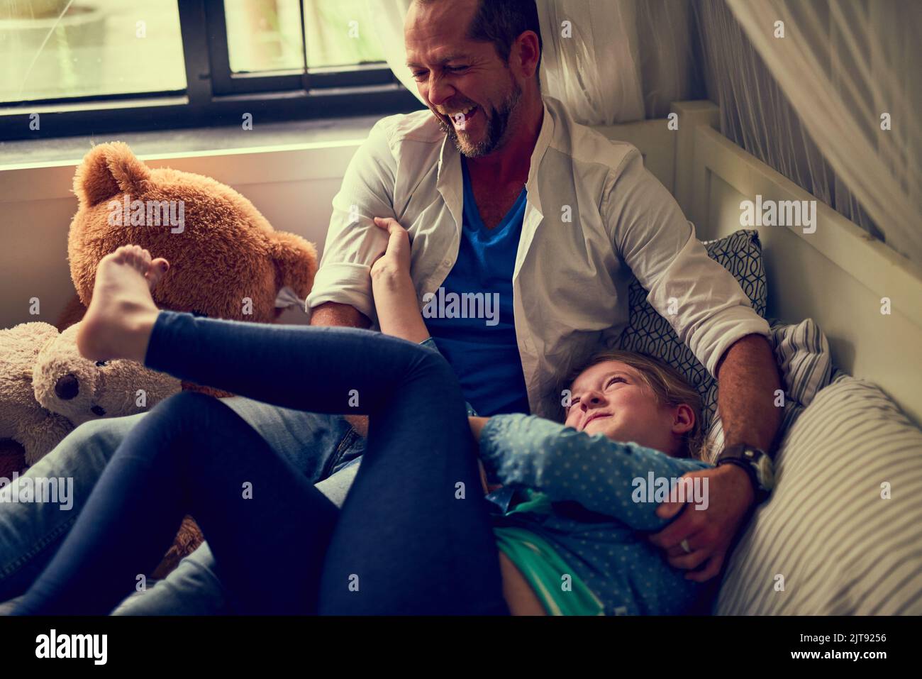 Tickle attack. a man spending some quality time with his daughter. Stock Photo