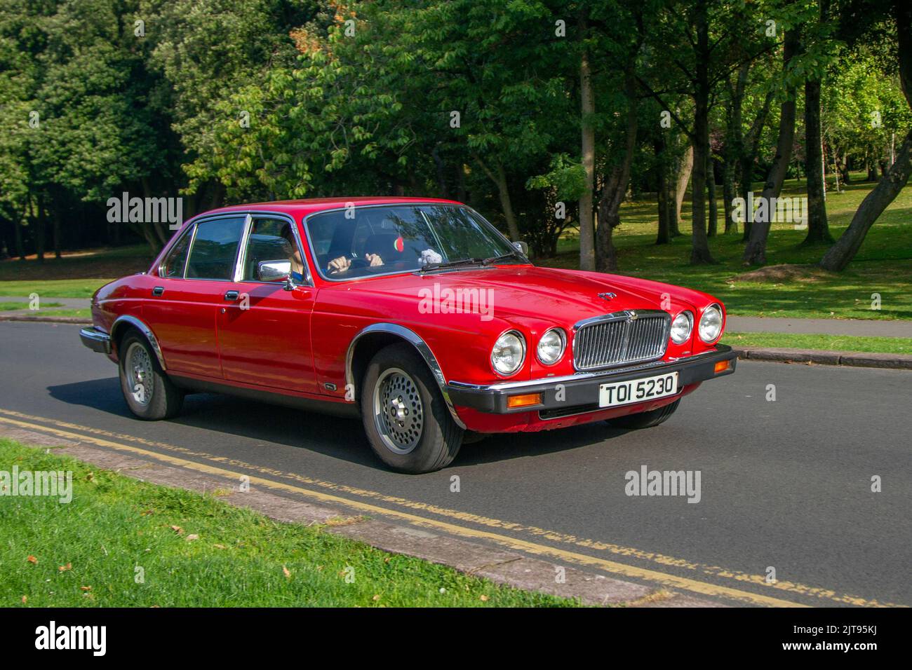 1983 80s eighties red JAGUAR, 4.2 Xj6 Auto saloon V6 Auto 4235cc Petrol British sports car; arriving at the annual Stanley Park Classic Car Show in the Italian Gardens. Stanley Park classics yesteryear Motor Show Hosted By Blackpool Vintage Vehicle Preservation Group, UK. Stock Photo