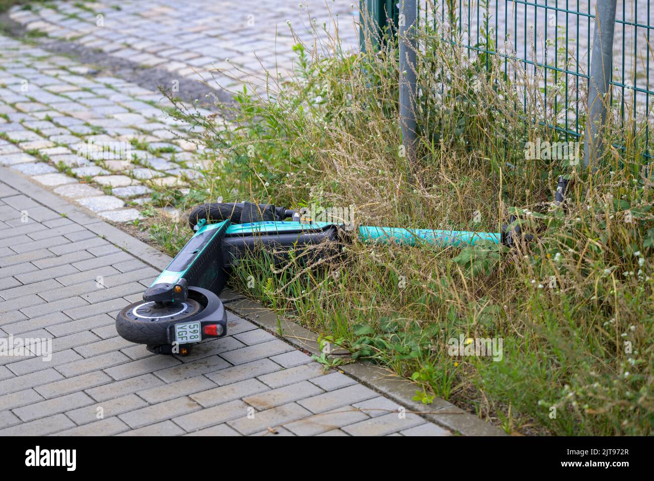 Germany , Cottbus , 21.08.2022 , An E - scooter from TIER Mobility after use simply thrown on the roadside Stock Photo