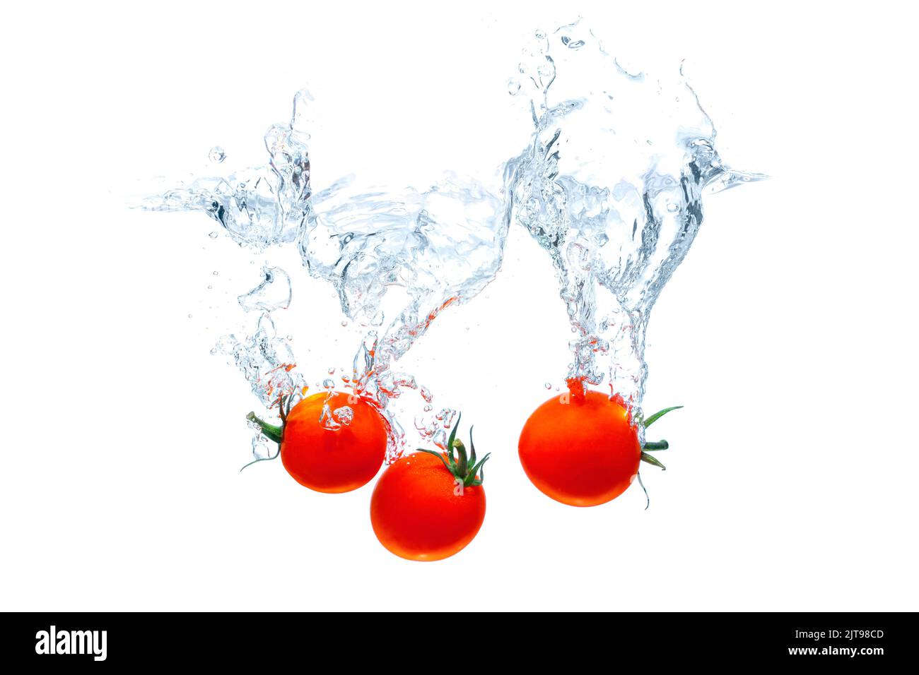 Cherry tomatoes dropped in water with big splashes isolated on white ...