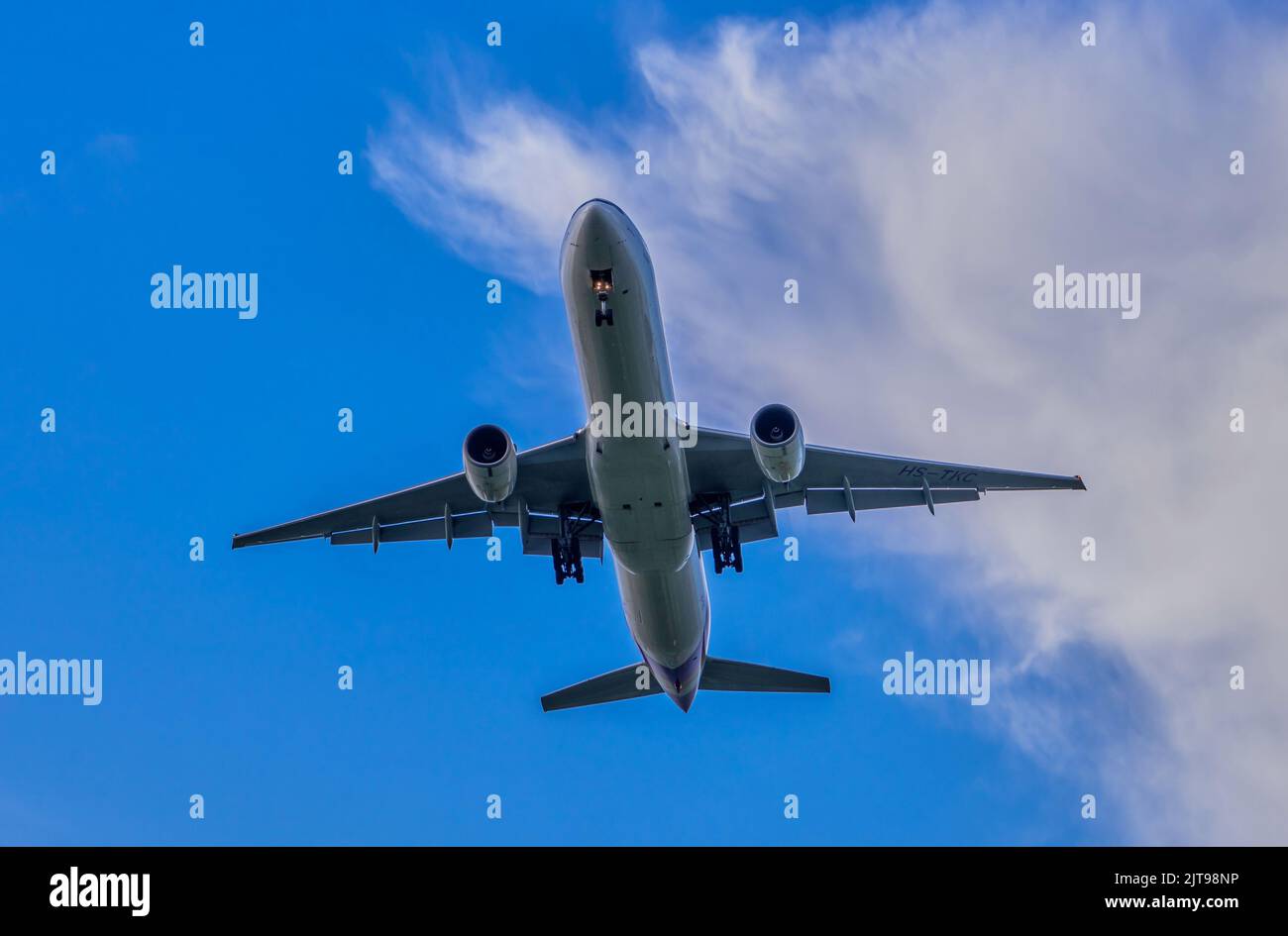 An airplane in a blue sky with white clouds Stock Photo - Alamy