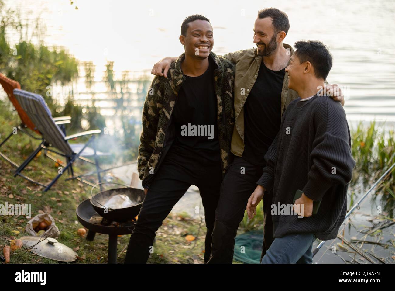 Three multiracial male friends having fun while fishing Stock Photo