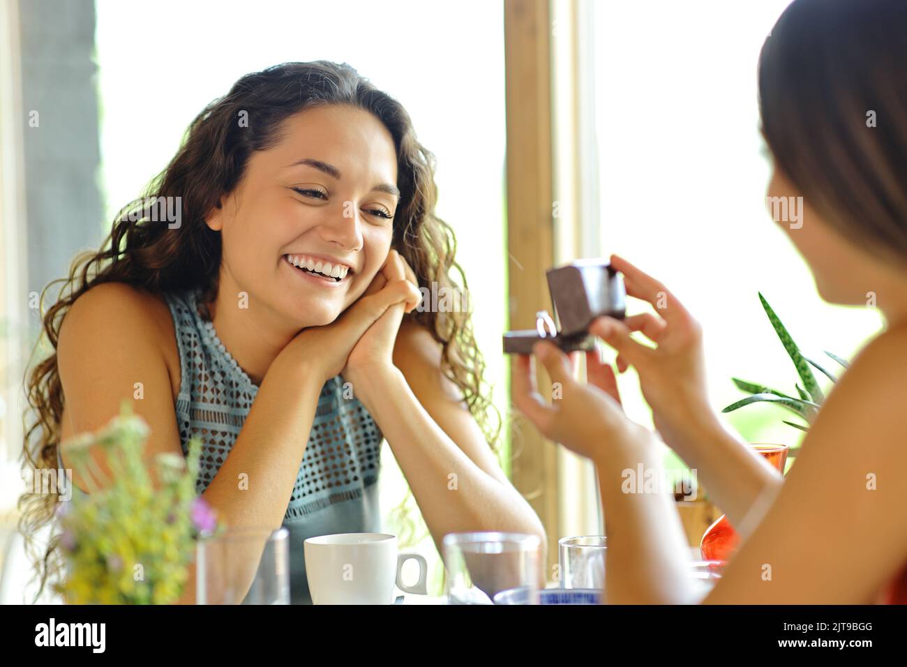 Marriage proposal of two happy lesbian women in a restaurant Stock Photo