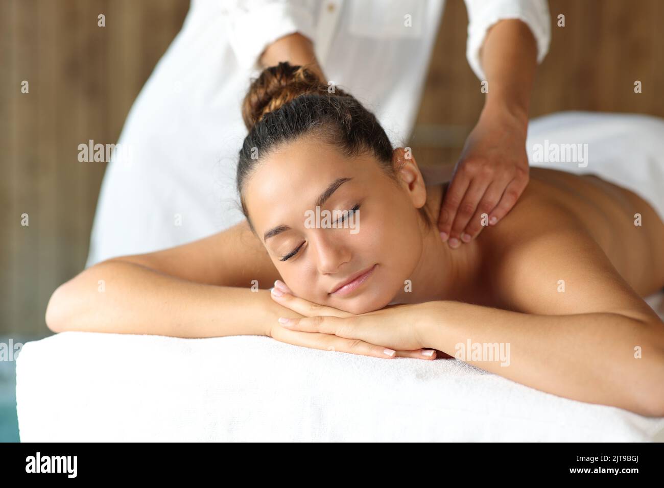 Massage therapist working with a happy client in a spa Stock Photo