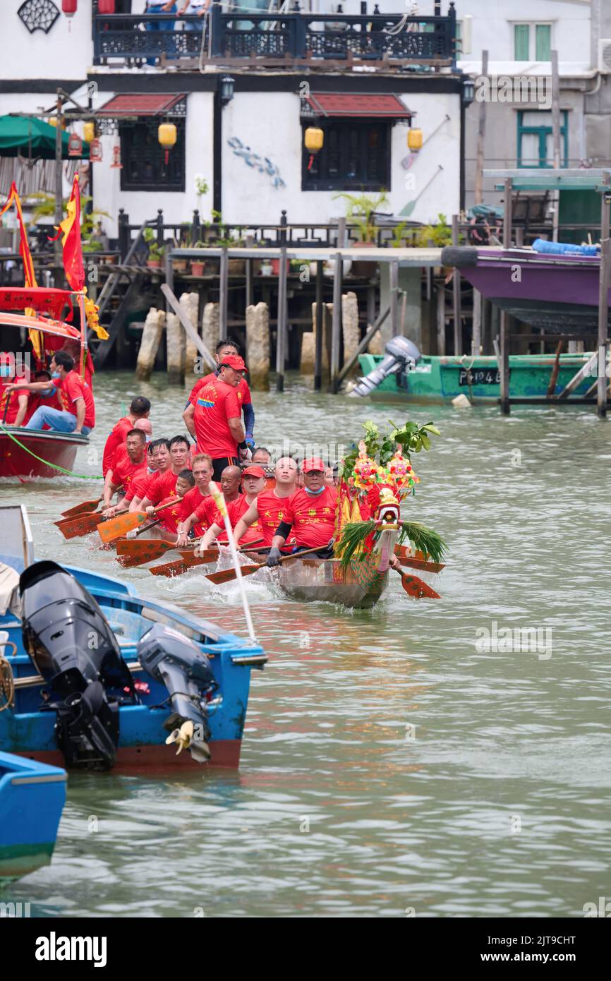 A vertical closeup of people riding on boats at the Dragon Boat ...