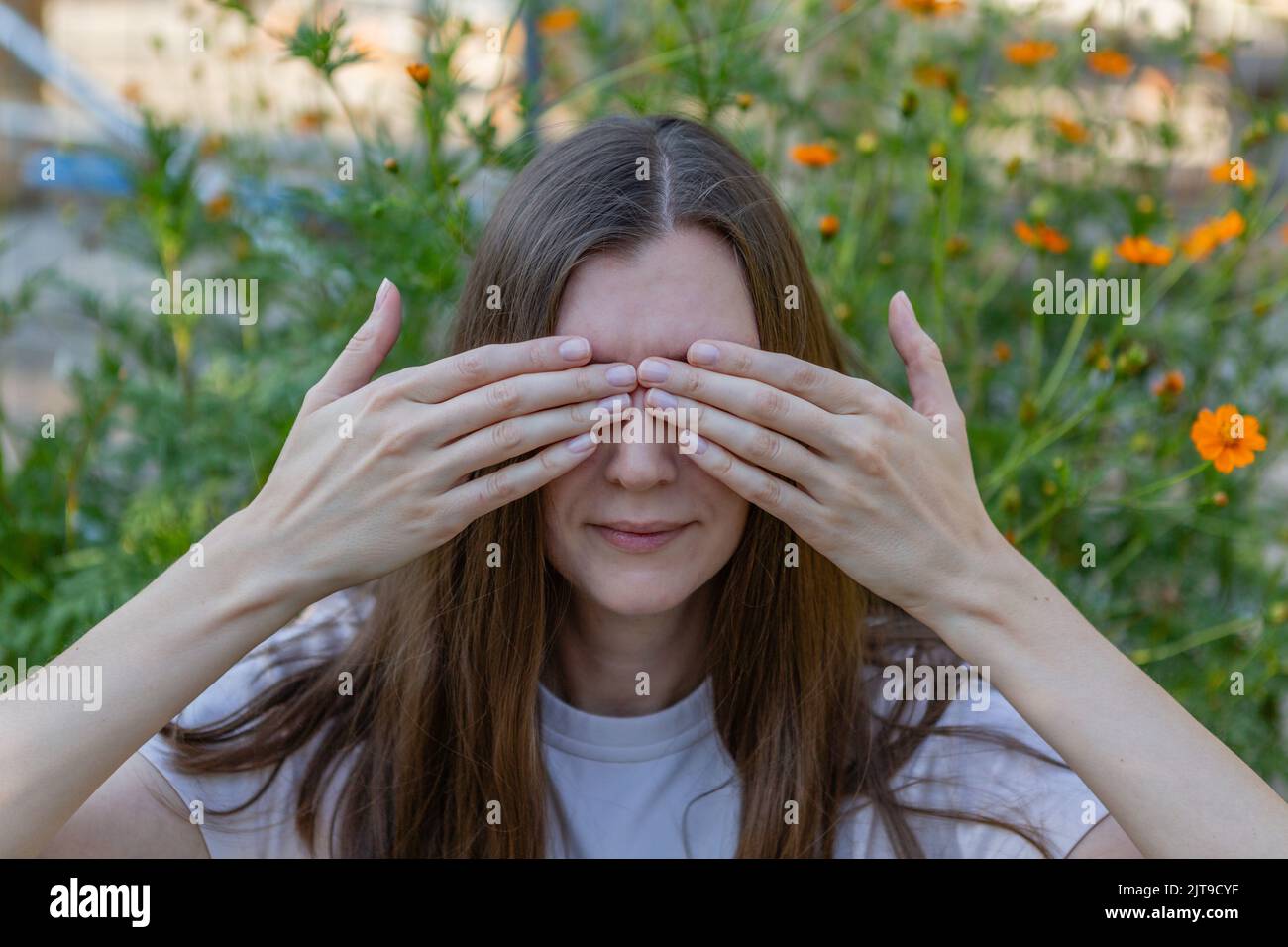 A woman covers her eyes with her hands Stock Photo