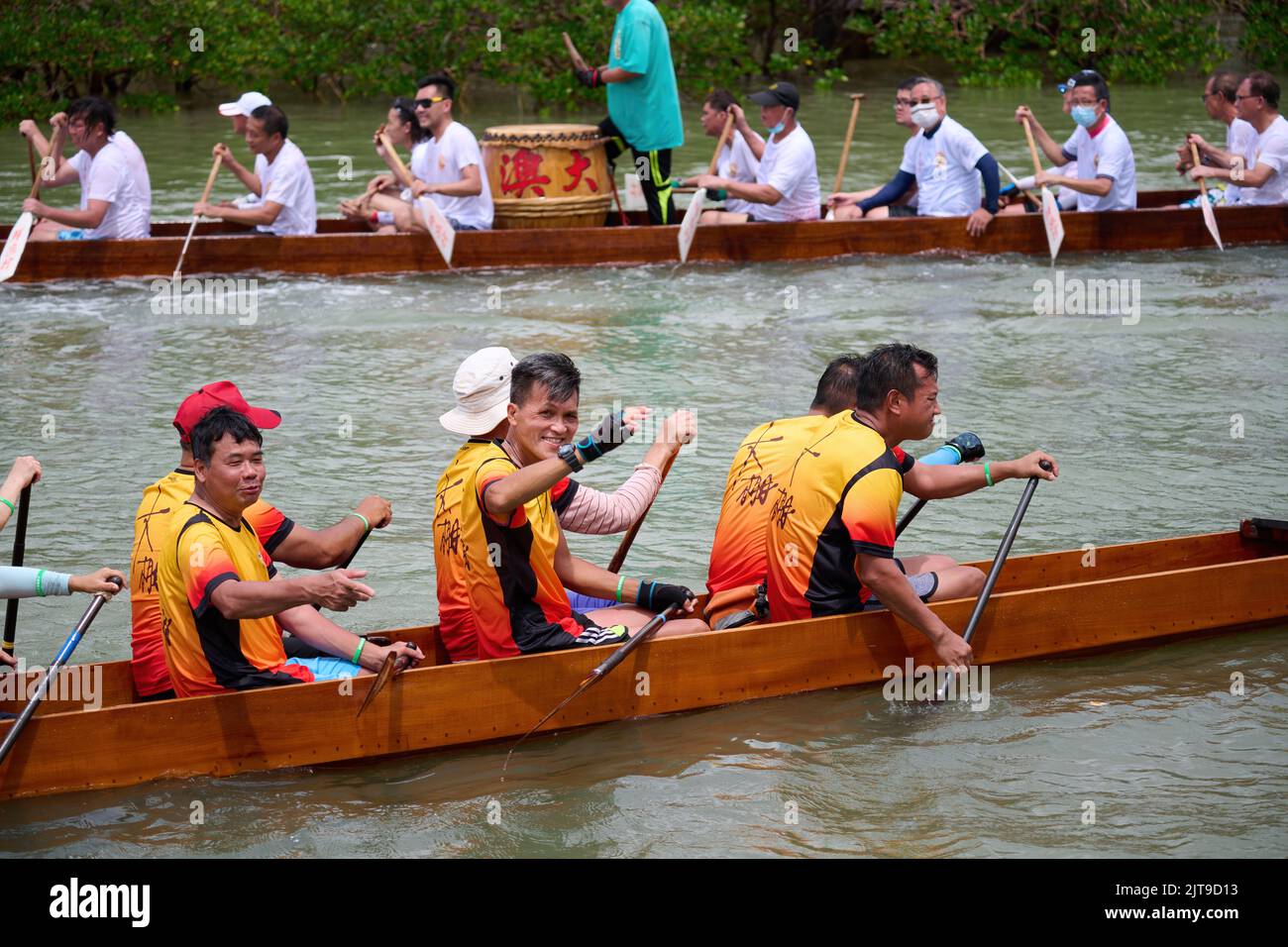 A closeup of People riding dragon boats at the Dragon Boat Festival in Tai O, Hong Kong Stock Photo