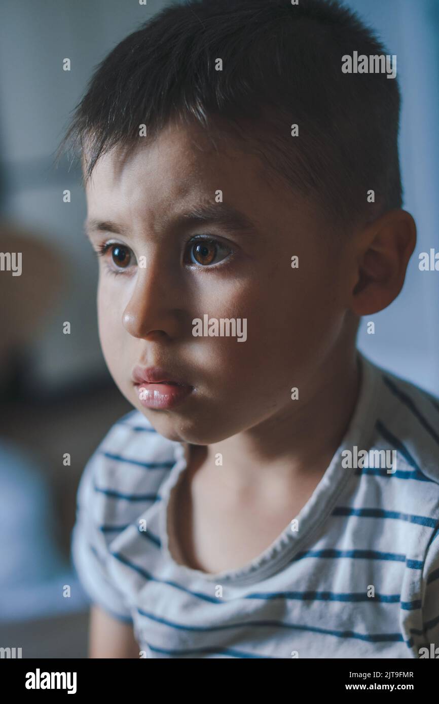 Close-up portrait of a concentrated boy looking at the TV obsessed with movies and games on the Internet. Bad habits. Covid 19 pandemic. Screen time Stock Photo