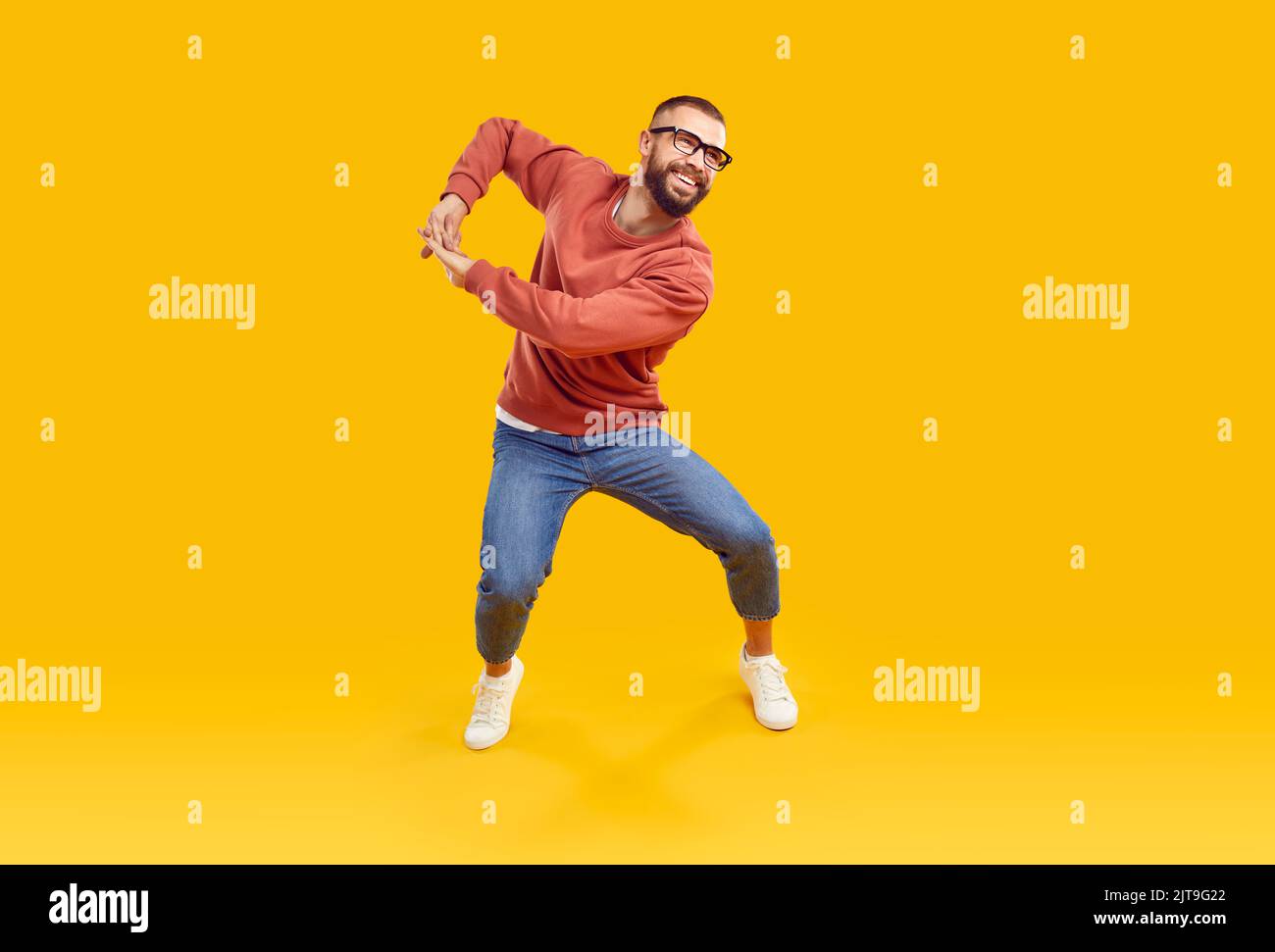 Happy cheerful young man in modern casual clothes dancing and having fun in studio Stock Photo