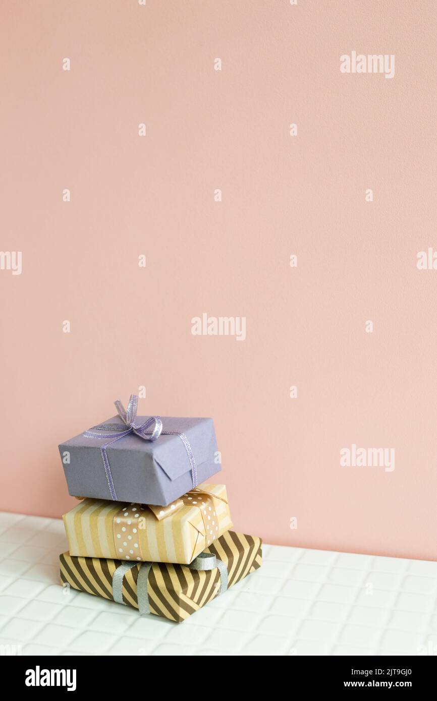 Colorful gift boxes on white table. pink wall background Stock Photo