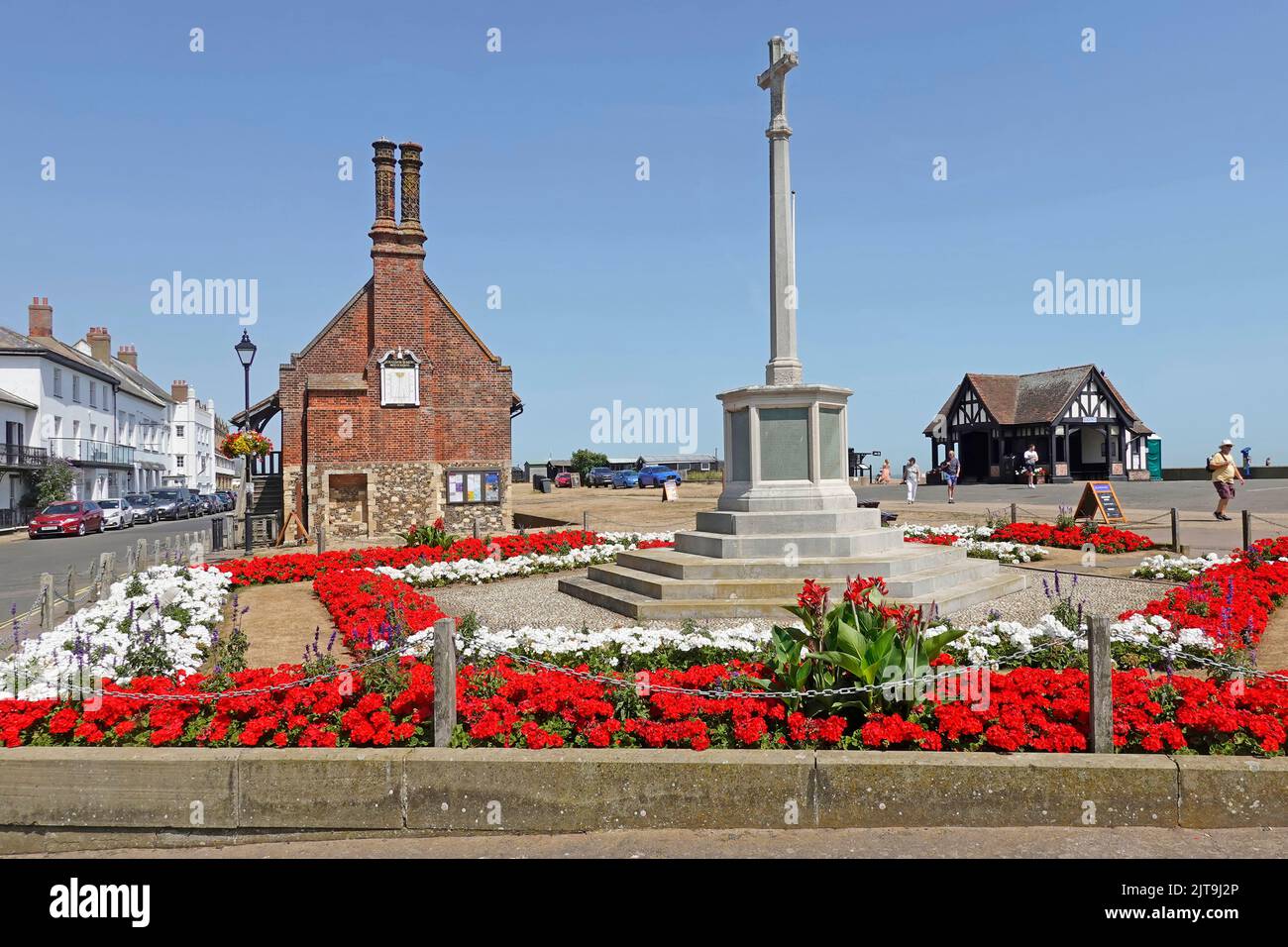 Vivid red Geraniums at War Memorial in Aldeburgh & historical 16th-century chimney Moot Hall now a local history museum Suffolk East Anglia England UK Stock Photo