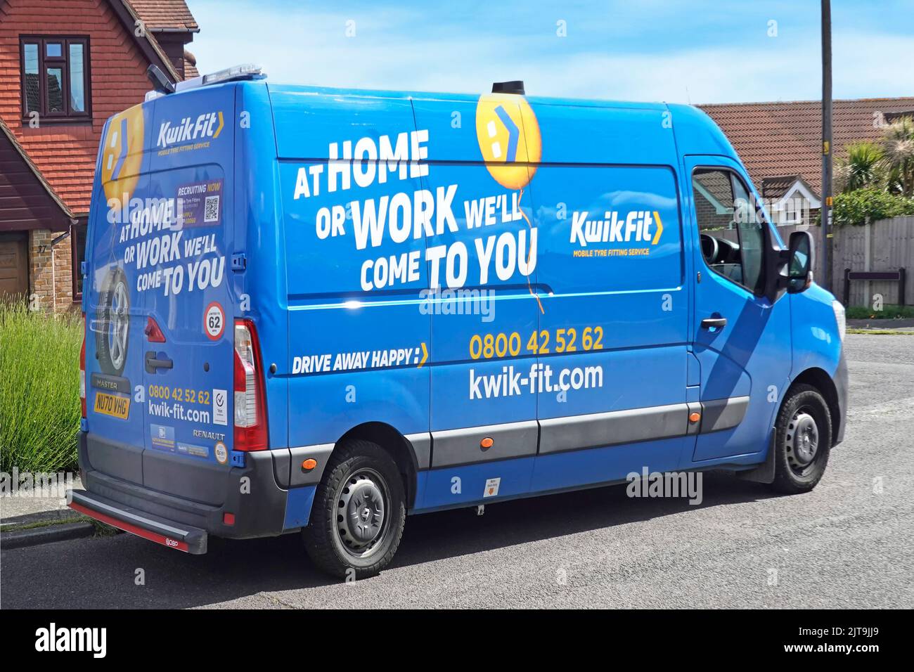 Side & back view Kwick Fit business Home or Work tyre fitting service blue Renault Master van parked outside residential property Essex England UK Stock Photo