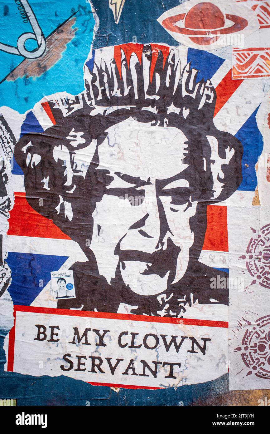 Anti-royalist placard with Queen Union Jack poster on wall in Bricklane , London , United Kingdom . Stock Photo