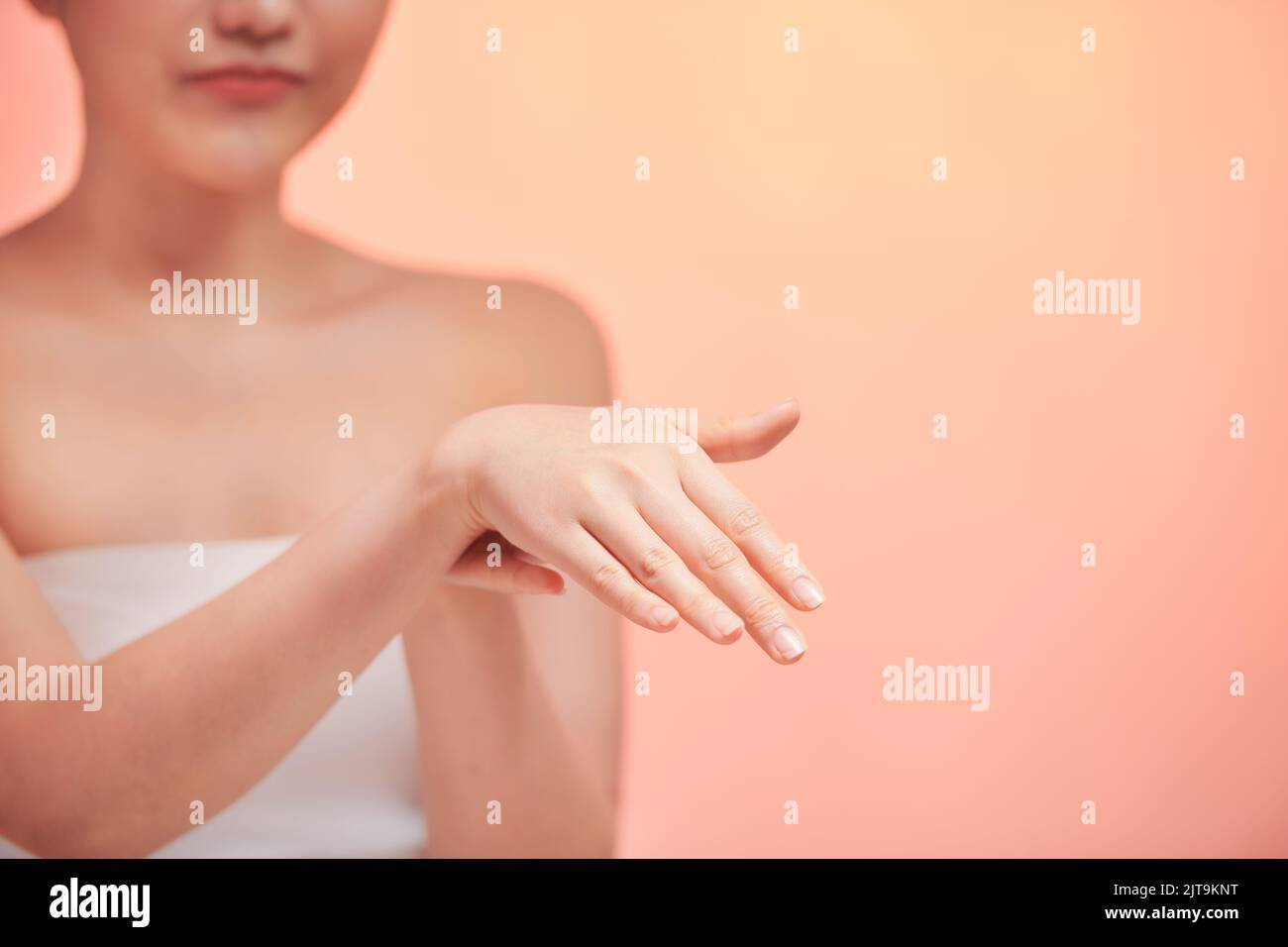 Beautiful young woman applying cosmetic moisturizer on hands Stock Photo
