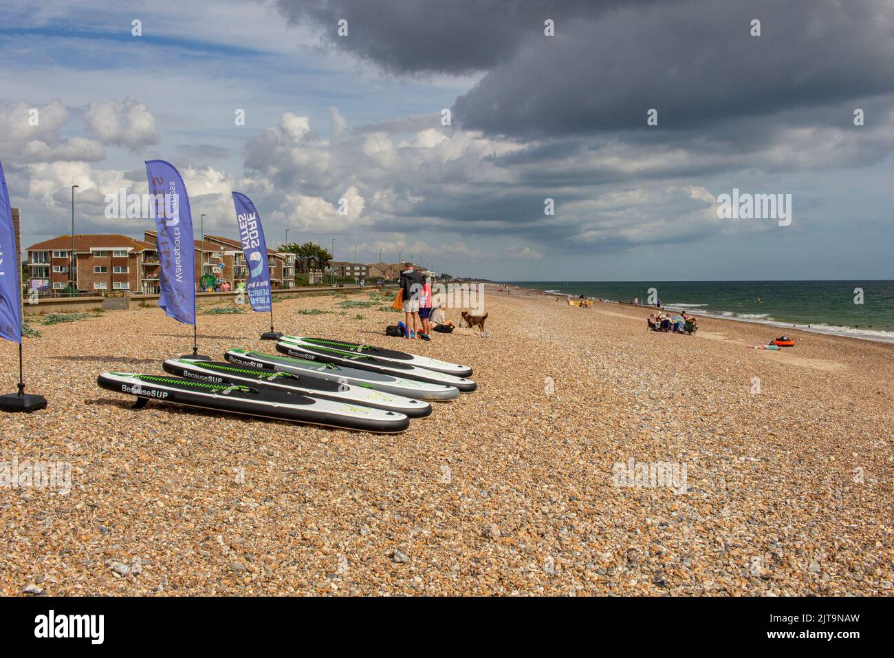The East Beach, Littlehampton, West Sussex, UK; showing The Beach, a cafe and centre for watersports, with paddle boards on the beach Stock Photo