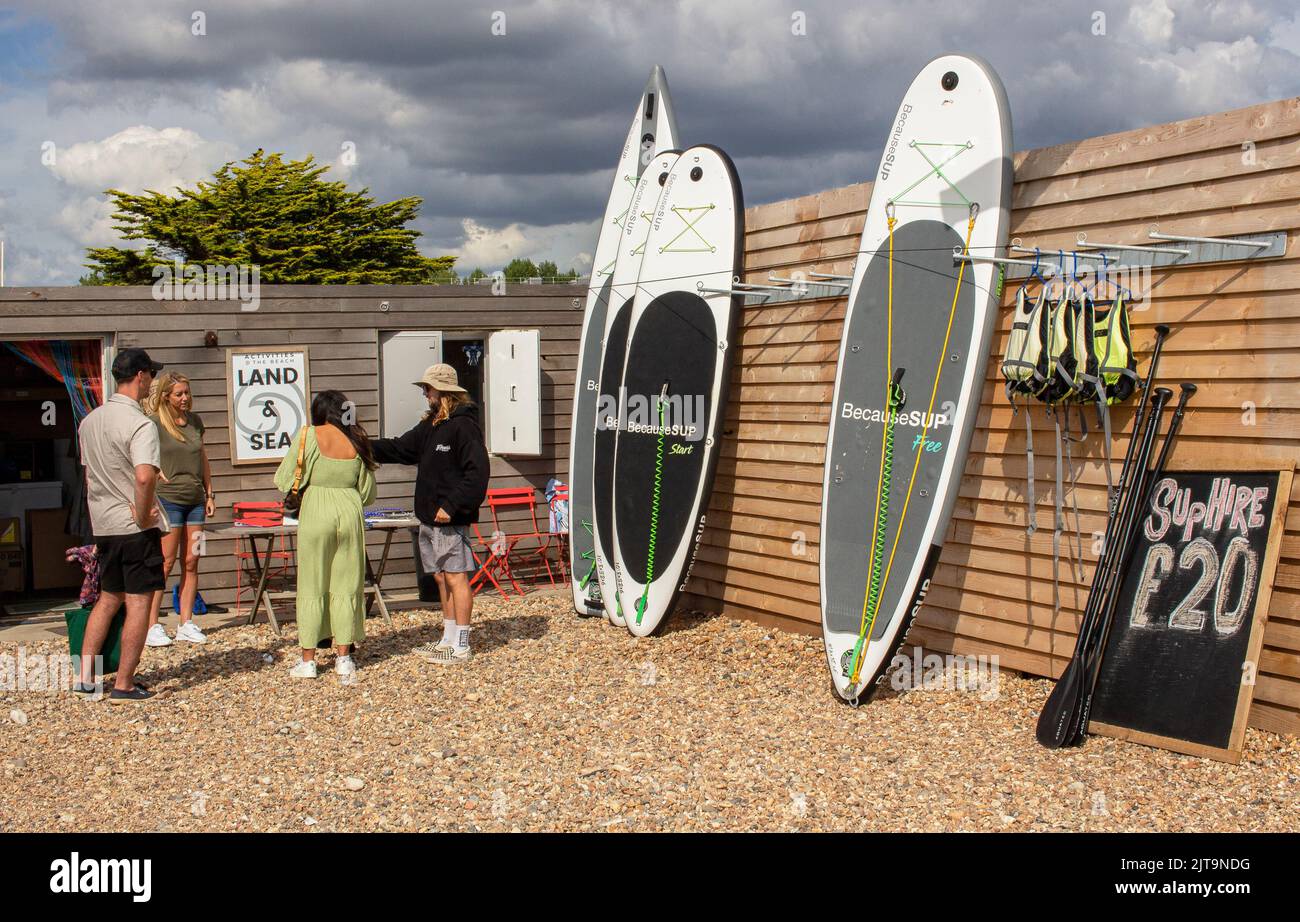 The East Beach, Littlehampton, West Sussex, UK; showing The Beach, a cafe and centre for watersports, with paddle boards on the beach Stock Photo