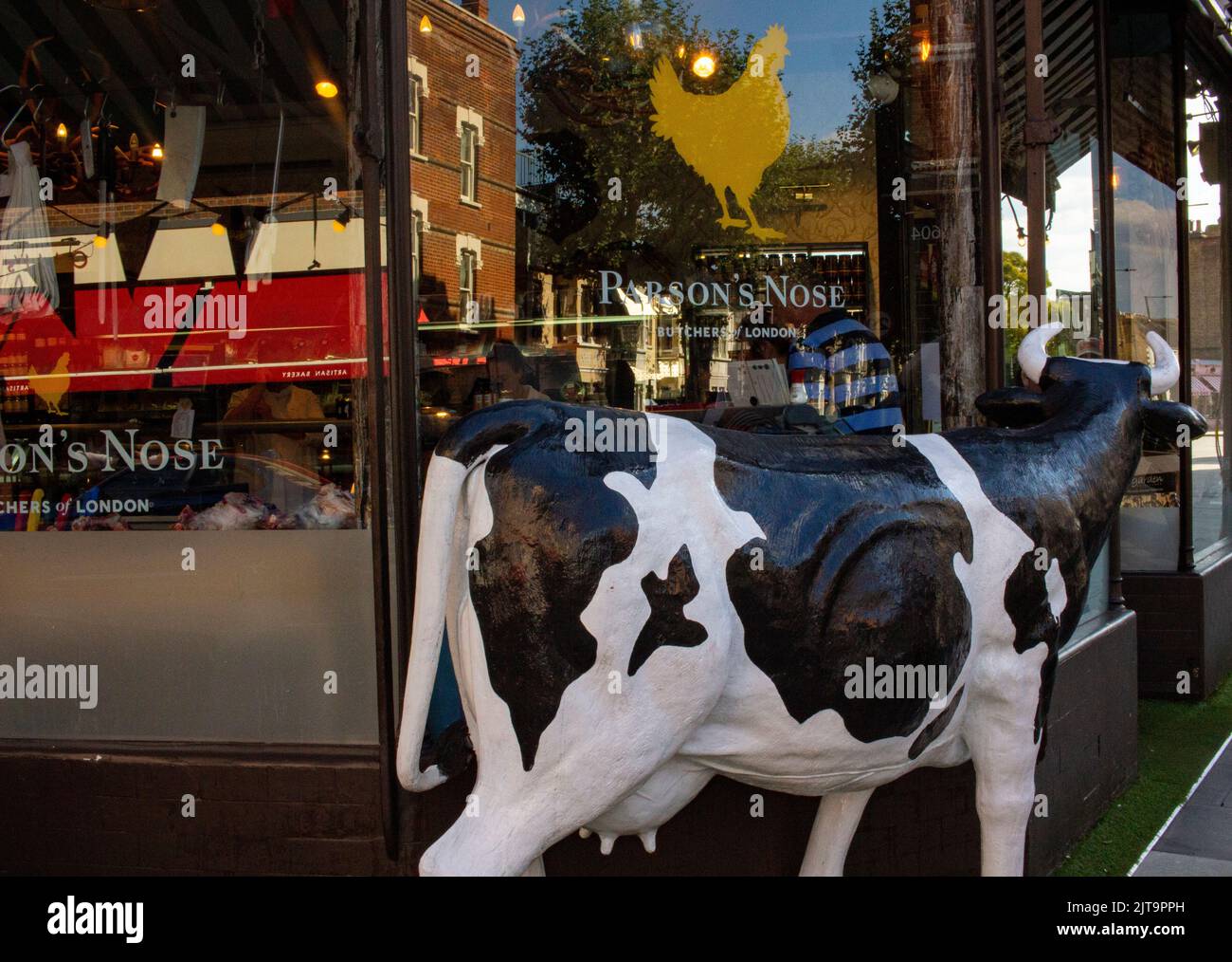 Life sized cow outside the Parson's Nose an upmarket butcher's shop in West London Stock Photo