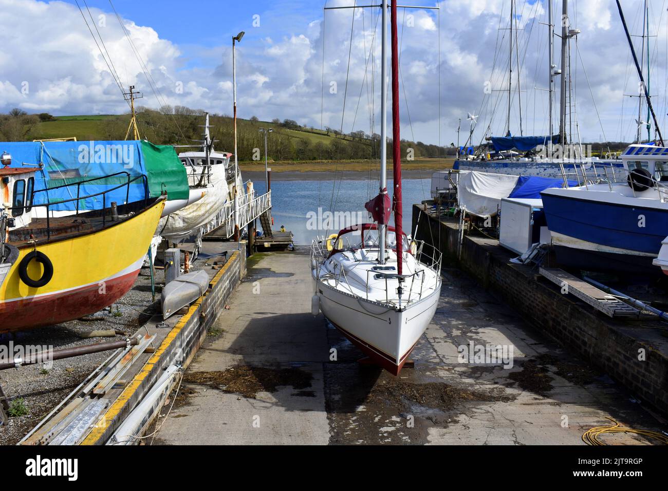 Sailing yacht on the slipway waiting to be launched back in the Cleddau river, East Llanion boatyard, East Llanion, Pembrokeshire, Wales Stock Photo