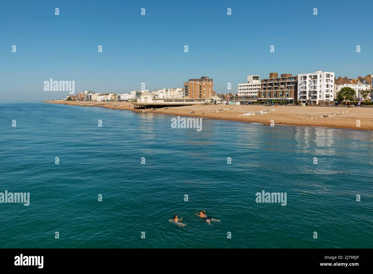 England, West Sussex, Worthing, Two Women Swimming in the Sea and Beach Skyline Stock Photo