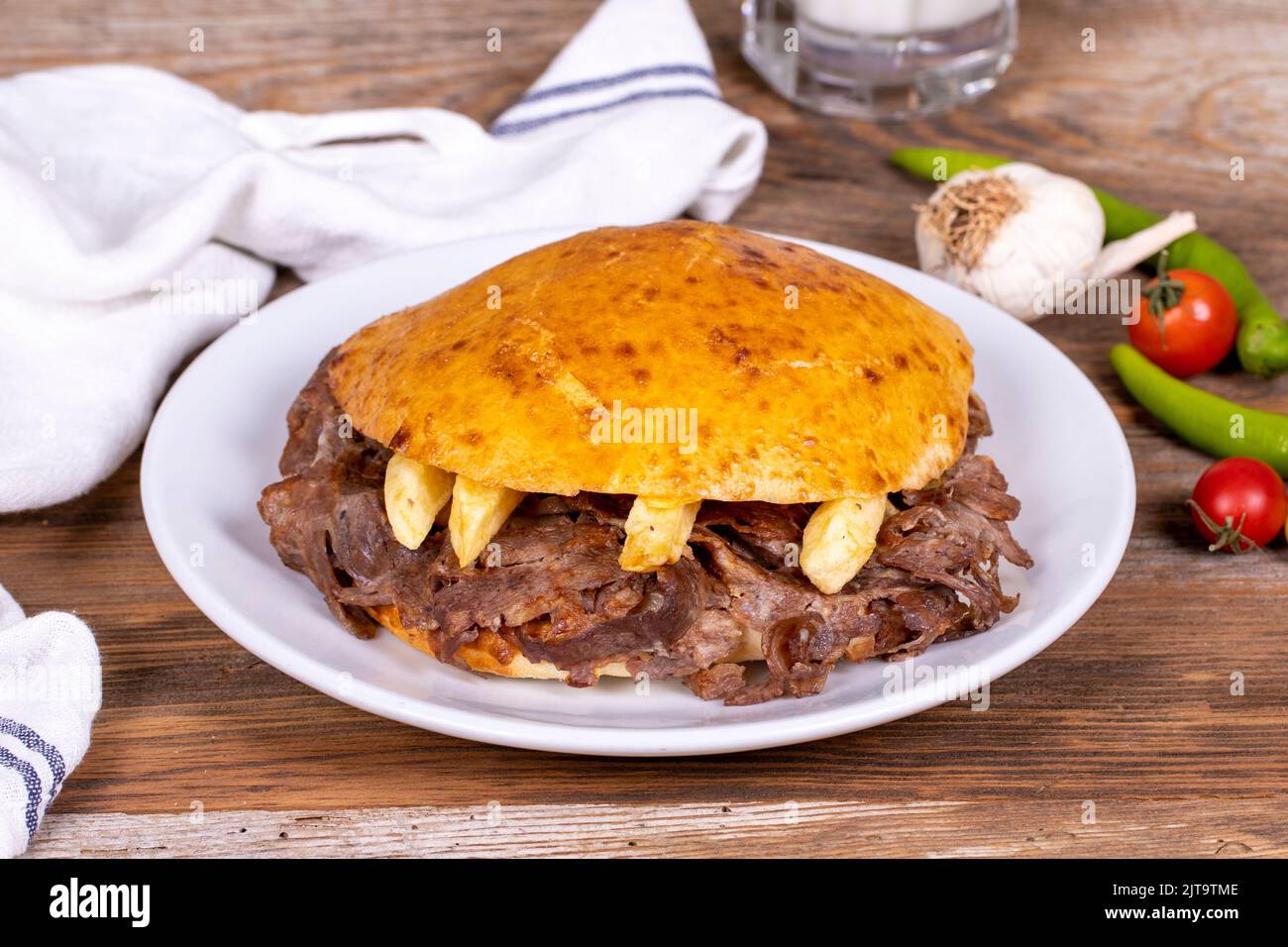 Meat between bread rolls. Meat doner in fat bread on wooden background