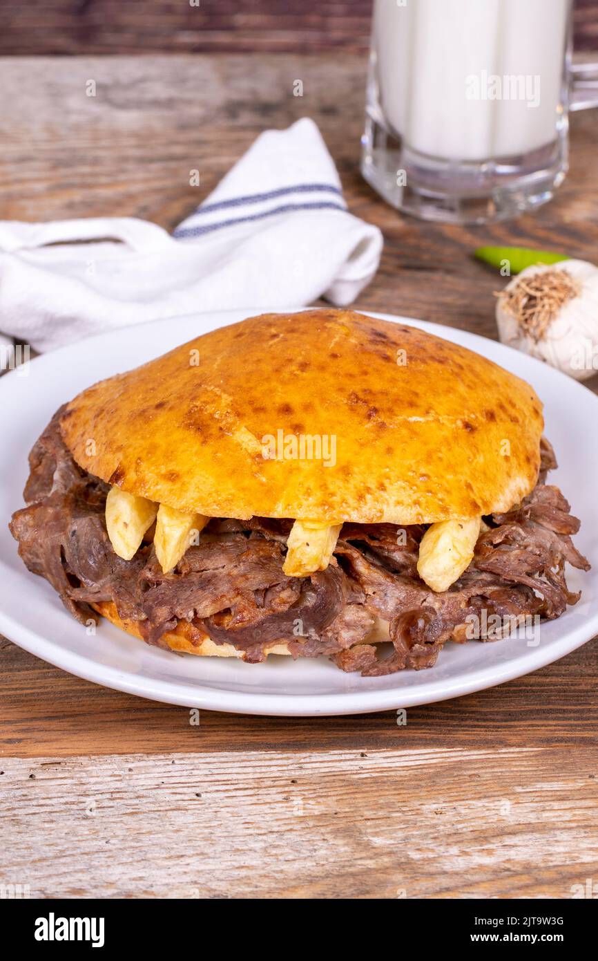 Meat between bread rolls. Meat doner in fat bread on wooden background