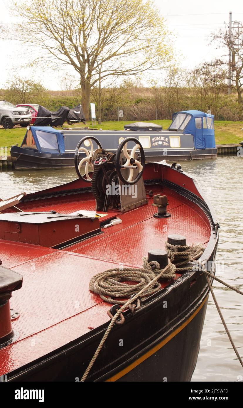 A partial view of a moored barge in the canal basin at Ely, Cambridgeshire, England, showing ropes, hull and the deck Stock Photo