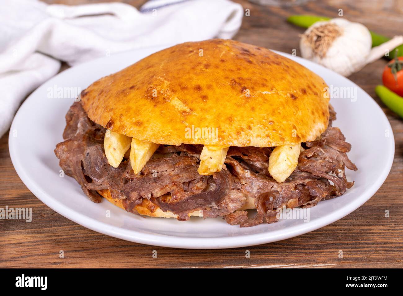 Meat between bread rolls. Meat doner in fat bread on wooden background