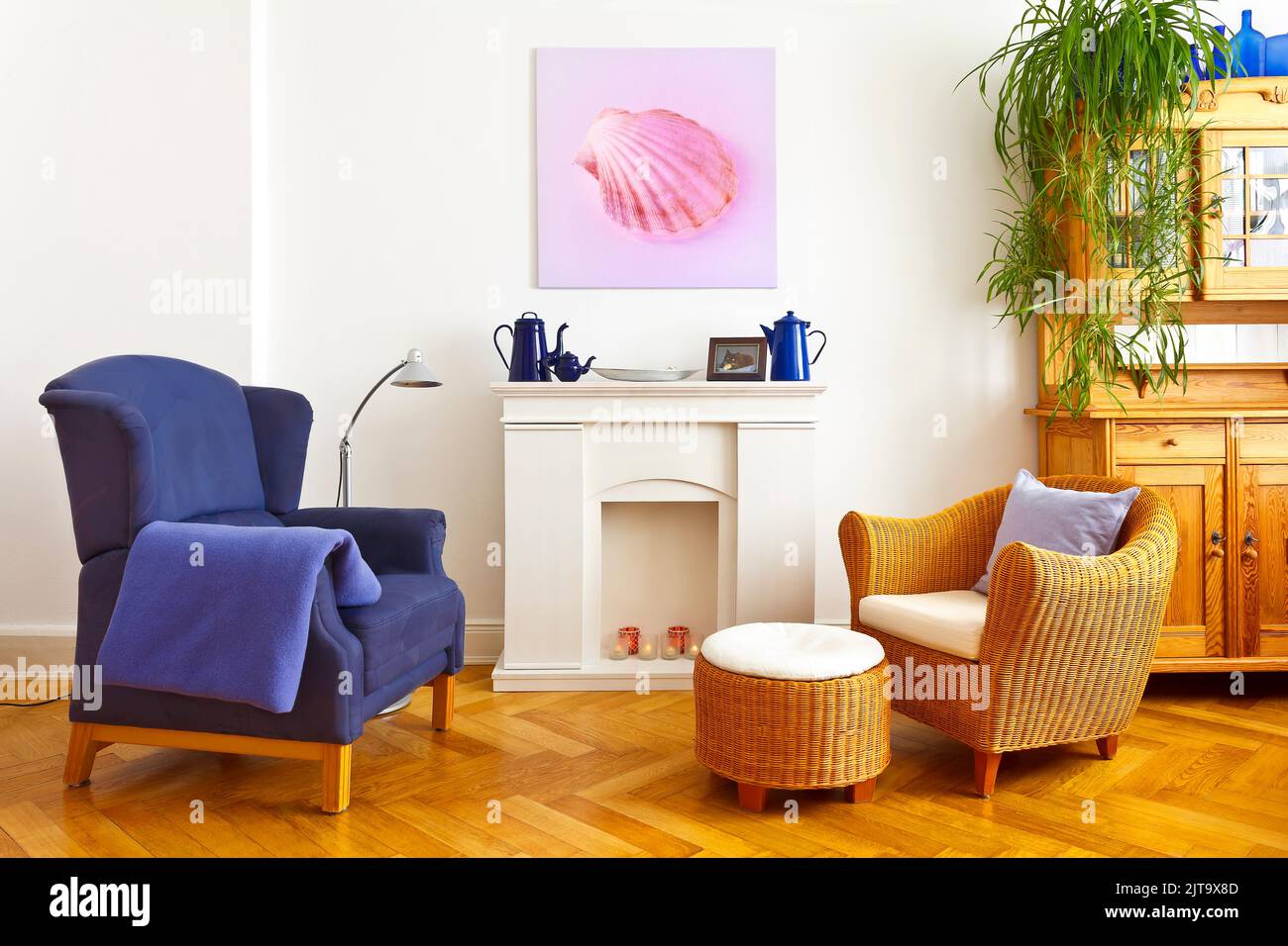 Custom-made home decoration concept: living room with a wing and a wicker chair, and a square canvas print of a pink shell picture. Stock Photo