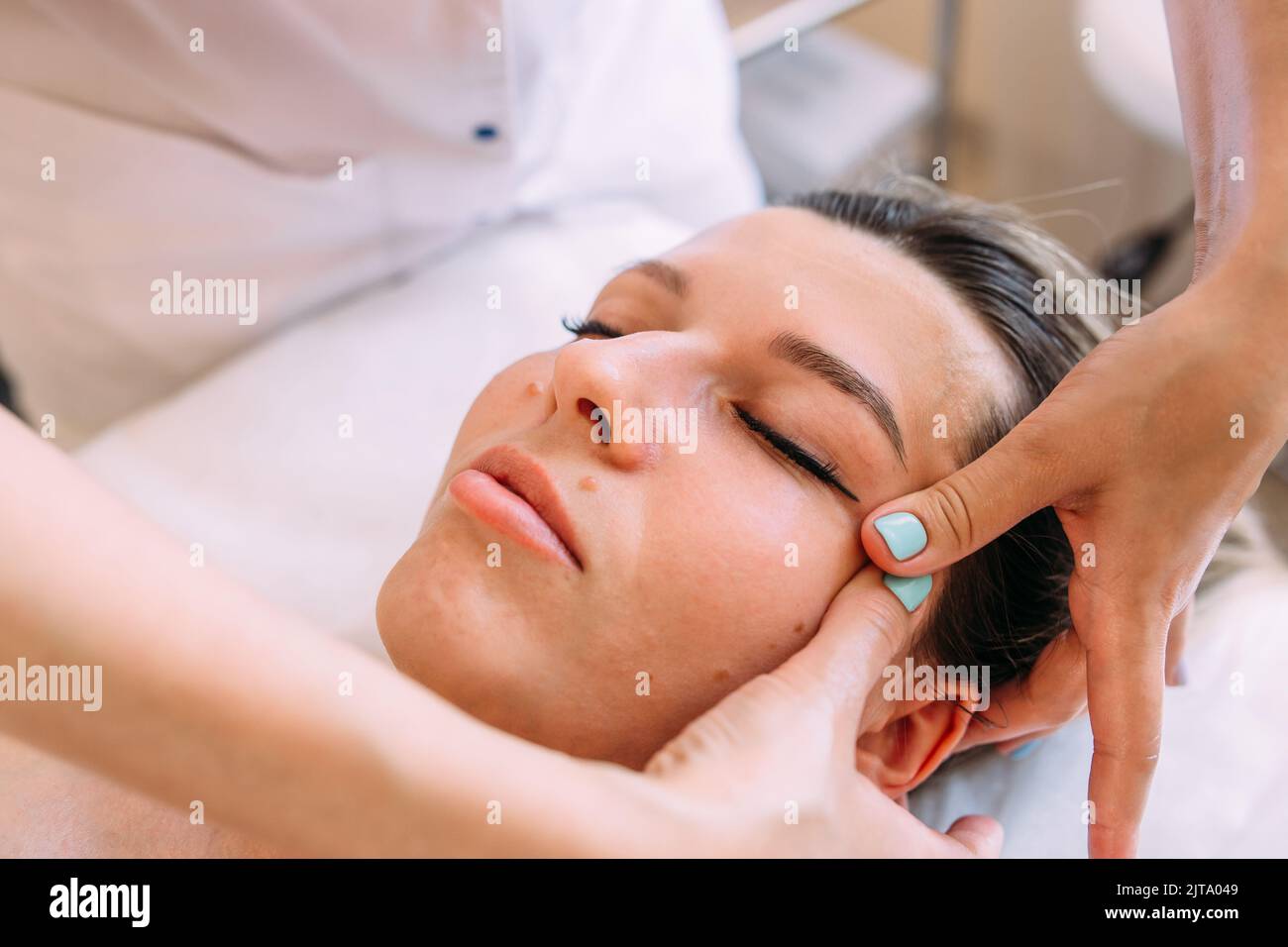 Cosmetologist does facial massage for woman. Beauty skin care Stock Photo