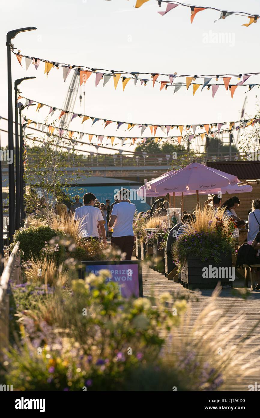 Bars, parasols, bunting and good vibes at Battersea Power Station's coal jetty in brilliant sunshine in the summer Stock Photo