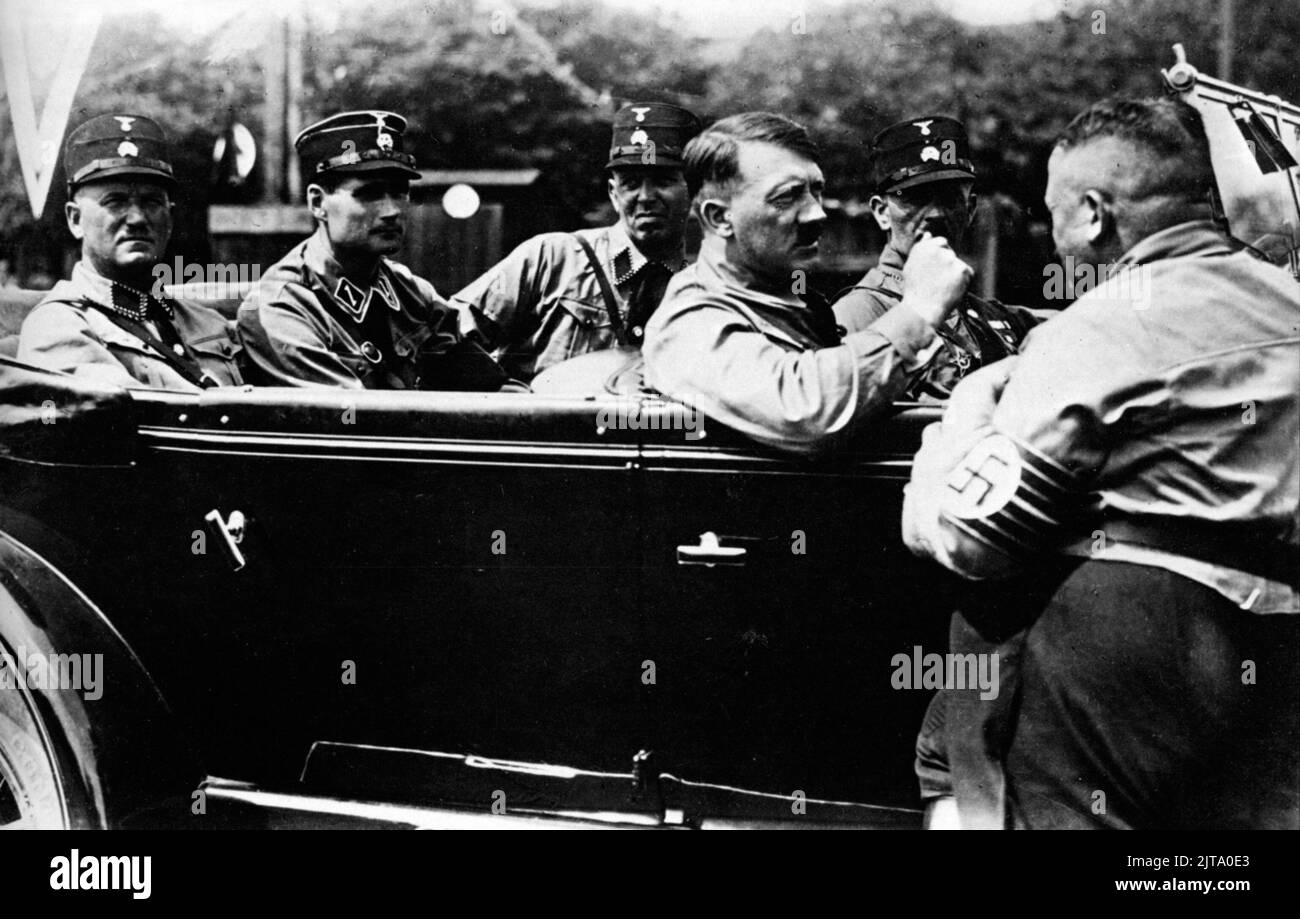 A vintage photo circa August 1929 in Nuremberg showing the future German Nazi dictator Adolf Hitler in an open top mercedes car with members of the Nazi party in storm trooper uniforms during a party rally.  Also in the photo are left to right Ulrich Graf, Rudolf Hess, Schaut and Michael Steinbinder Stock Photo