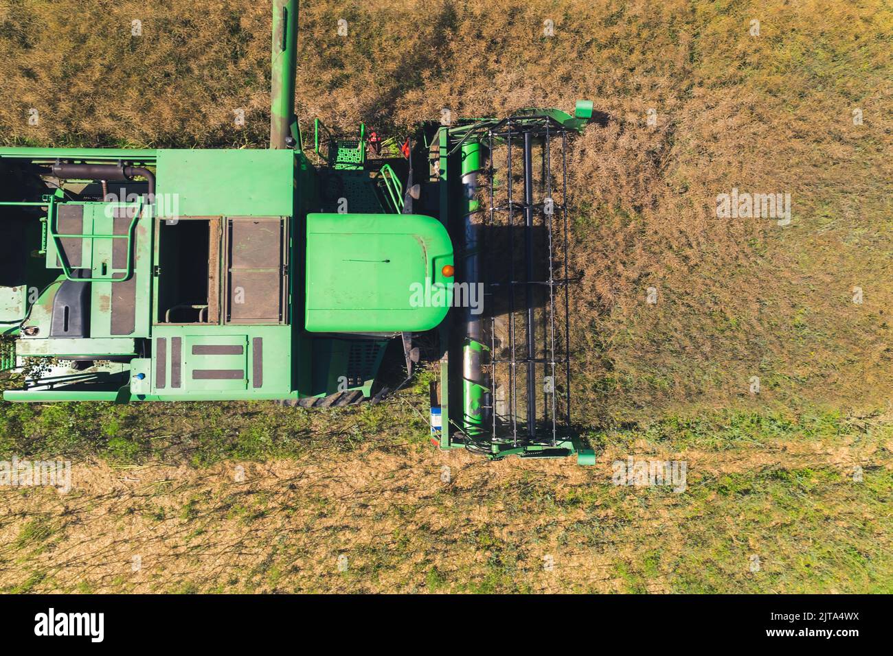 Top aerial view of a green agricultural combine with a revolving reel ...