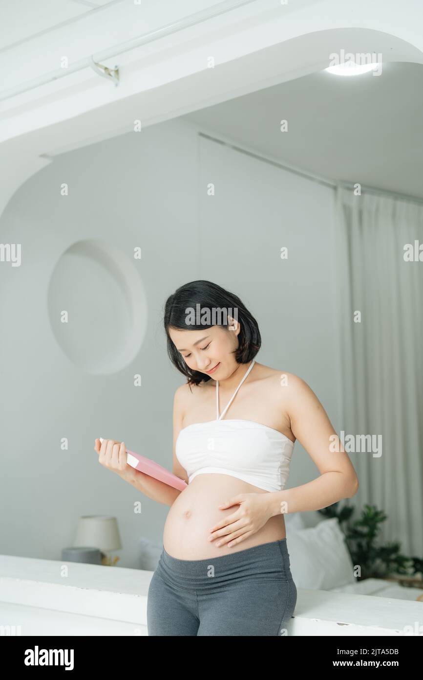 Beautiful pregnant woman reading a book Stock Photo